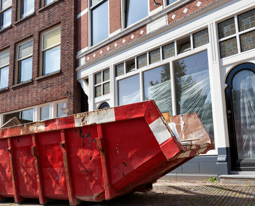 Dumpster On Sidewalk In Front Of Building